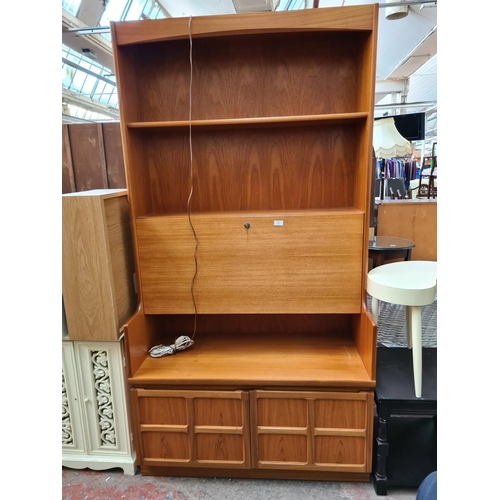 564 - A Nathan teak wall unit with fall front and two lower cupboard doors - measuring approx. 196cm high