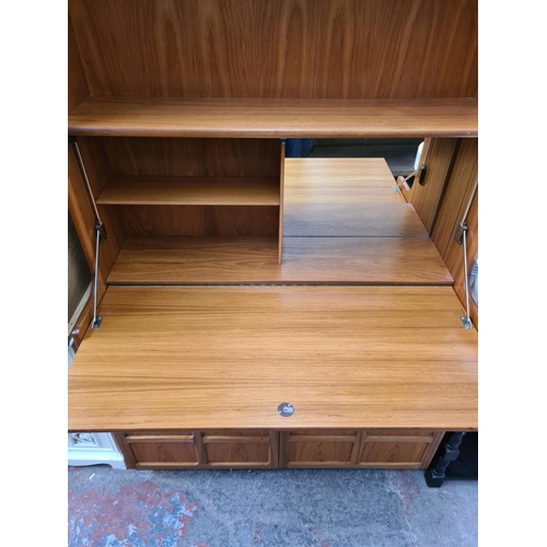 564 - A Nathan teak wall unit with fall front and two lower cupboard doors - measuring approx. 196cm high