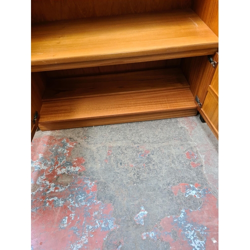 564 - A Nathan teak wall unit with fall front and two lower cupboard doors - measuring approx. 196cm high