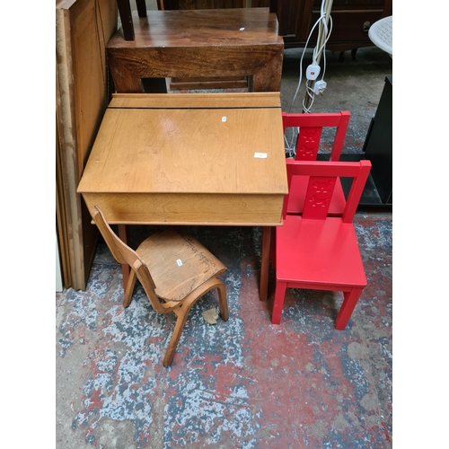 572 - A mid 20th century plywood child's school desk and chair together with a pair of Ikea Kritter red ch... 