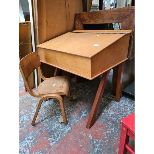 572 - A mid 20th century plywood child's school desk and chair together with a pair of Ikea Kritter red ch... 