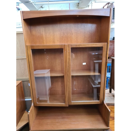 577 - A Nathan teak wall unit with two upper glazed doors and two lower cupboard doors - measuring approx.... 