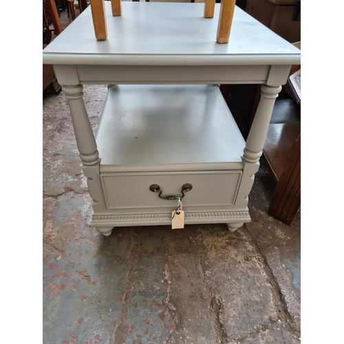 582 - A grey painted two tier side table with one drawer and a vintage beech sewing stool with blue leathe... 