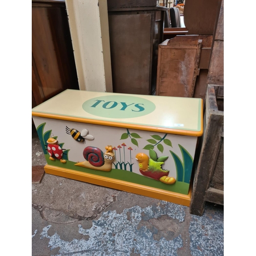 595 - A modern painted child's toy box with insect design - measuring approx. 44cm high, 88cm wide and 37c... 