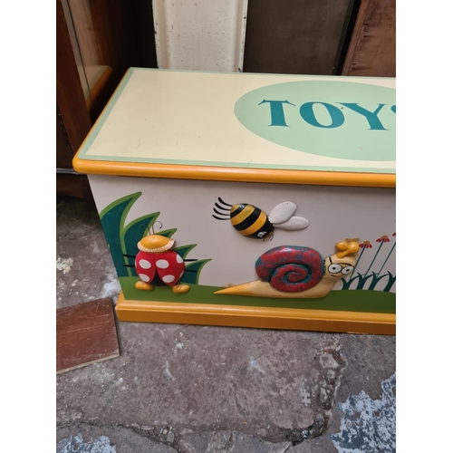 595 - A modern painted child's toy box with insect design - measuring approx. 44cm high, 88cm wide and 37c... 