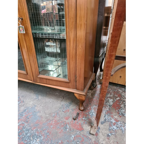 599 - A walnut display cabinet on cabriole supports with two glazed doors and mirrored interior - measurin... 