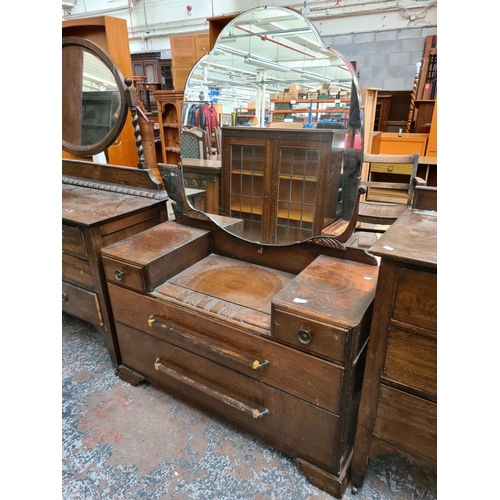 601 - An Art Deco oak dressing table with upper bevel edged mirror and four drawers