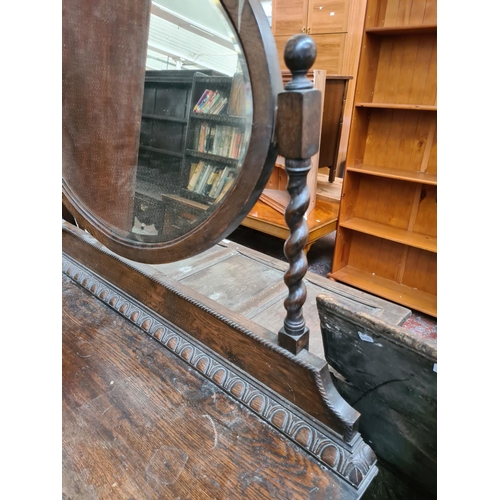 602 - An early 20th century oak dressing table with two short over two long drawers and upper bevel edged ... 