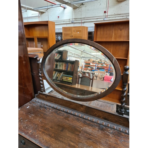 602 - An early 20th century oak dressing table with two short over two long drawers and upper bevel edged ... 