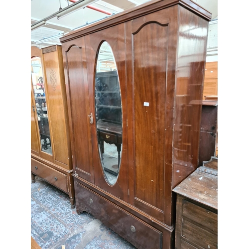 603 - An early 20th century mahogany single door wardrobe with central bevel edged mirror