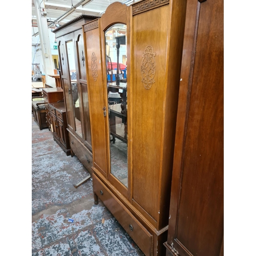 604 - A 1930's oak single door wardrobe with central bevel edged mirror