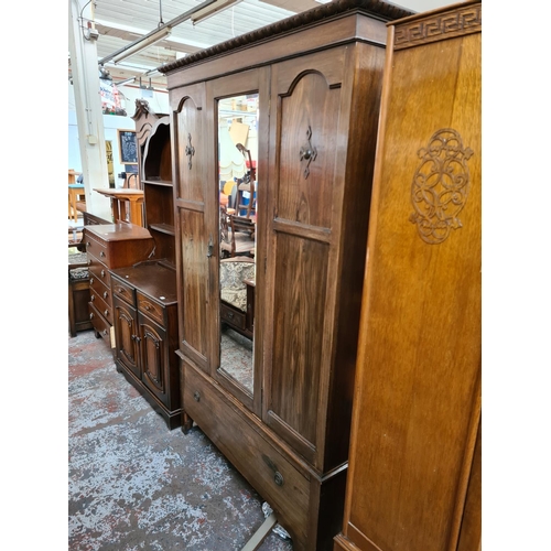 605 - An early 20th century oak single door wardrobe with central bevel edged mirror