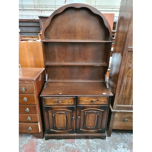 606 - An oak Dutch dresser with upper plate rack, two drawers and two doors - measuring approx. 183cm high... 