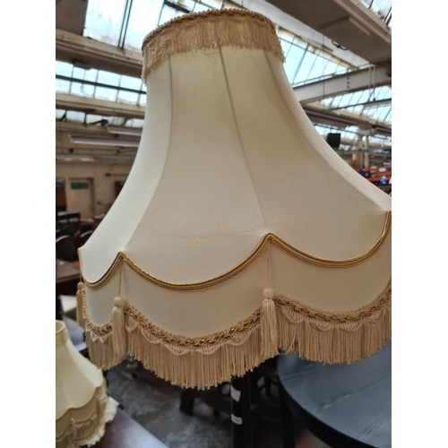 622 - An oak standard lamp with tassel shade and two spare shades