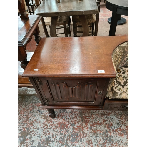 623 - An oak telephone table with green upholstered seat and one cupboard door - measuring approx. 70cm hi... 