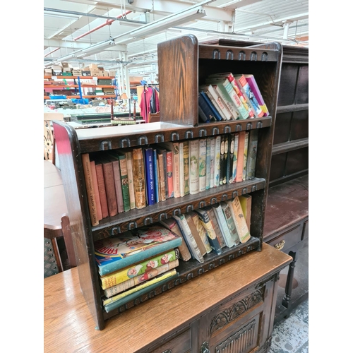 627 - An oak three tier bookcase containing a large quantity of vintage books to include Walt Disney's Sno... 