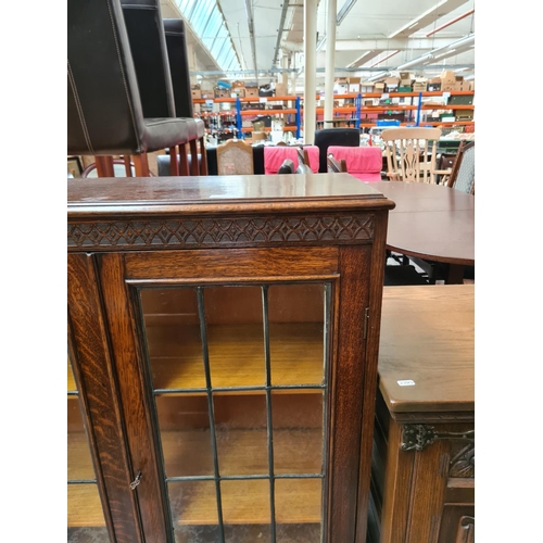 629 - An early 20th century oak bookcase on cabriole supports with two glazed doors and key - measuring ap... 