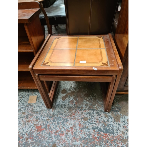 630 - A teak nest of two tables with tile inserts