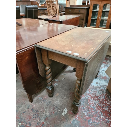 634 - An oak drop leaf dining table on barley twist supports