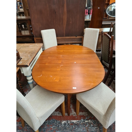 639 - A teak drop leaf dining table and four modern beige upholstered dining chairs on oak supports