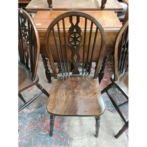 640 - Five items to include an oak drop leaf dining table on barley twist supports, three elm wheel back d... 