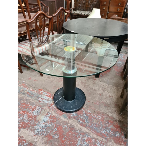 643A - A contemporary glass topped circular pedestal dining table on marble effect base