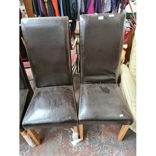 651 - A set of four brown leatherette high back dining chairs on light oak supports