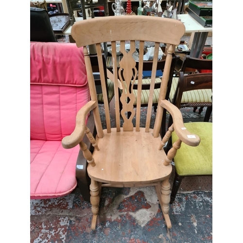 654 - A Victorian style solid beech farmhouse rocking chair with carved fretwork back - measuring approx. ... 