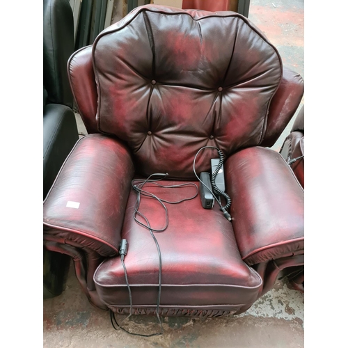 662B - An oxblood leather three piece lounge suite comprising three seater sofa and two reclining armchairs