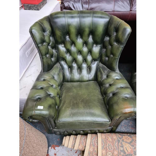 662C - A Chesterfield style green leather three piece lounge suite comprising three seater sofa and two arm... 