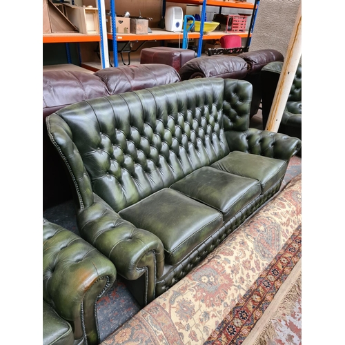 662C - A Chesterfield style green leather three piece lounge suite comprising three seater sofa and two arm... 