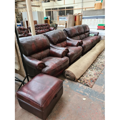 662D - An oxblood leather four piece lounge suite comprising three seater sofa, two armchairs and matching ... 