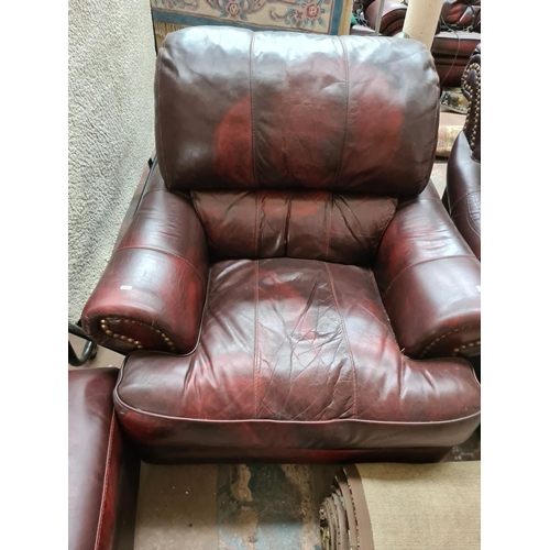 662D - An oxblood leather four piece lounge suite comprising three seater sofa, two armchairs and matching ... 