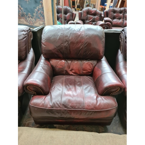 662D - An oxblood leather four piece lounge suite comprising three seater sofa, two armchairs and matching ... 