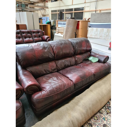 662D - An oxblood leather four piece lounge suite comprising three seater sofa, two armchairs and matching ... 