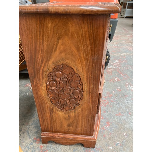 647A - An oriental style carved rosewood effect four drawer cabinet with brass inlay and swan neck handles ... 