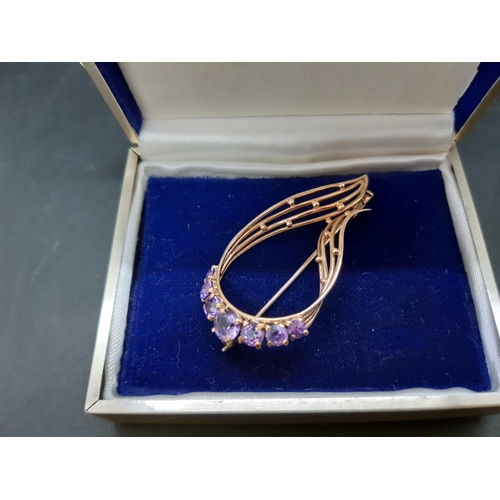 107 - An Art Nouveau style hallmarked 9ct gold ladies brooch with seven inset amethyst stones - approx. to... 