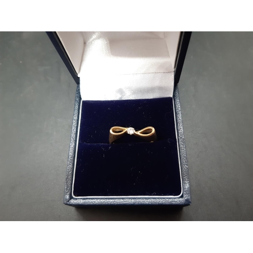 108 - A hallmarked 18ct gold bow shaped ring with inset diamond - approx. total weight 2.8 grams and size ... 