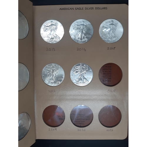 138 - A Dansco Archival slipcased coin album containing 32 american eagle silver dollars ranging from 1986... 