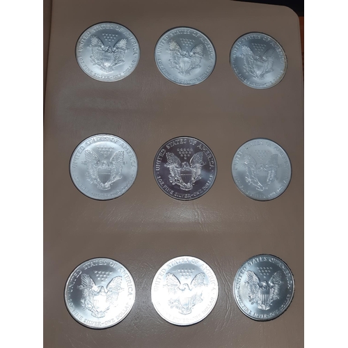 138 - A Dansco Archival slipcased coin album containing 32 american eagle silver dollars ranging from 1986... 