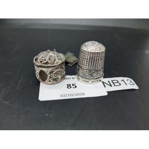 85 - Two items to include a hallmarked Birmingham silver thimble and a white metal filigree tape measure ... 