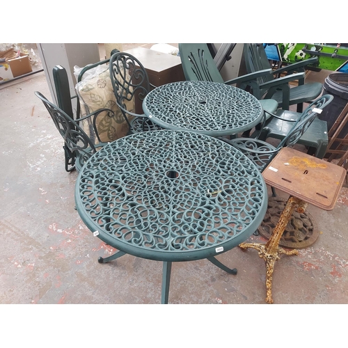 689 - Seven items to include two green circular cast aluminium patio tables with three chairs, garden sunl... 