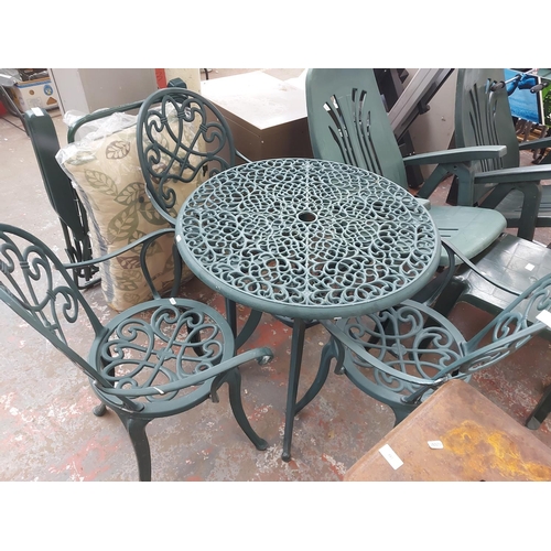 689 - Seven items to include two green circular cast aluminium patio tables with three chairs, garden sunl... 