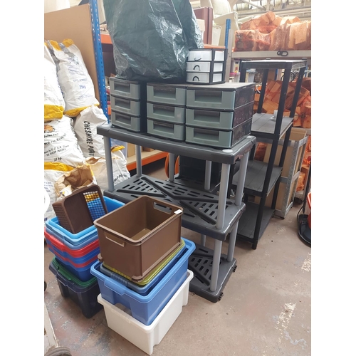 711 - A large quantity of plastic storage solutions to include shelving, boxes, three drawer desk filing c... 