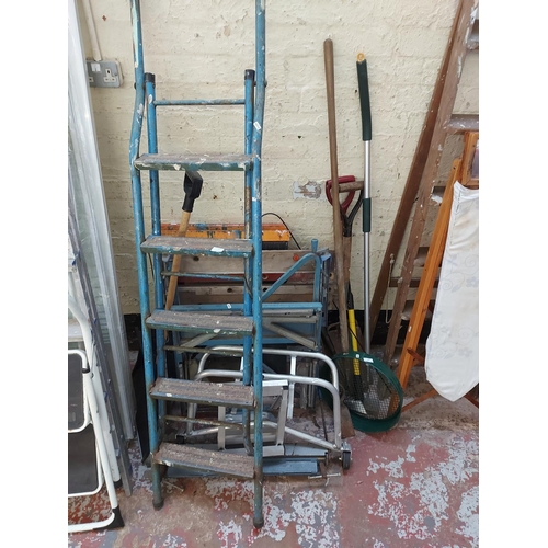 774 - A mixed lot to include Black and Decker workmate, plastic work trestles, five tread metal step ladde... 