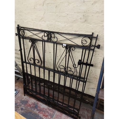 778 - A pair of black painted ornate metal garden gates measuring approx. 49