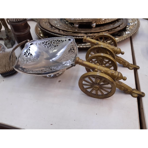 155 - A collection of various metalware to include two cast metal brass effect desk cannons, brass charger... 