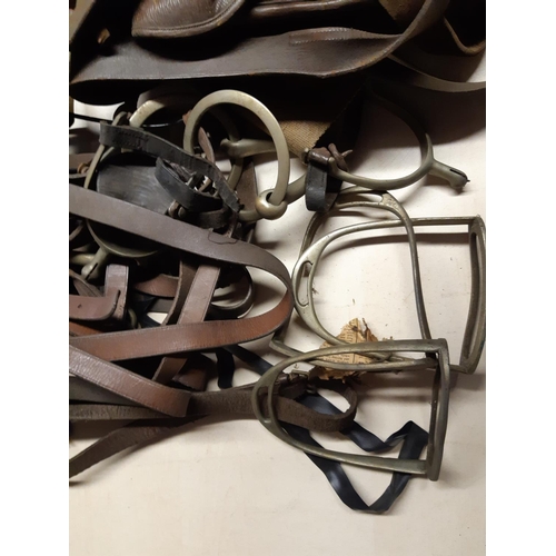 297 - A quantity of vintage horse tack to include brown leather saddle bags, stirrups etc.