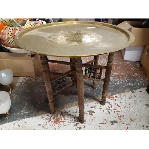 315 - A Middle Eastern folding travel table with well detailed etched brass charger top - measuring approx... 