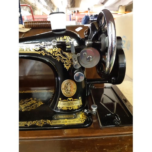 334 - A vintage mahogany cased Singer hand crank sewing machine - Serial No. Y9855402